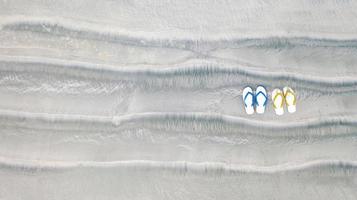 flip-flops på sandstrand, sommarlovsbakgrund, flygvy ovanifrån