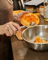 kock nedskärningar melon bollar med särskild sked i kök foto