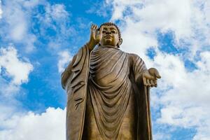 jätte gyllene buddha stående naturskön i buddist plats foto