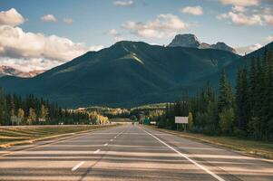 väg resa med bil körning med klippig bergen på motorväg i banff nationell parkera foto