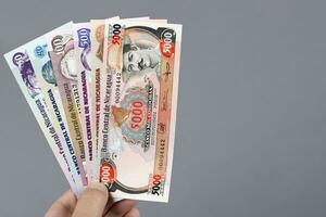 nikaraguanska pengar i de hand på en grå bakgrund foto