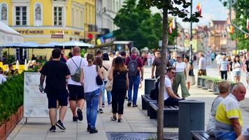 Warszawa, polen. 29 juli 2023. folkmassan av människor gående på en gata. en folkmassan rör på sig mot en bakgrund av ett urban gammal stad landskap. foto