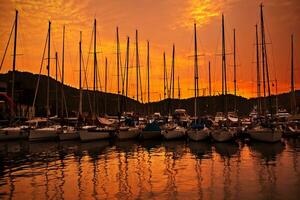 Yacht hamn över orange solnedgång foto