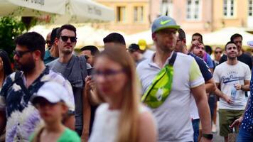 Warszawa, polen. 29 juli 2023. folkmassan av människor gående på en gata. en folkmassan rör på sig mot en bakgrund av ett urban gammal stad landskap. foto