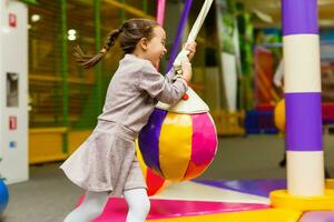 barn Hoppar på färgrik lekplats trampolin. barn hoppa i uppblåsbar studsa slott på dagis födelsedag fest aktivitet och spela Centrum för ung barn. liten flicka spelar utomhus i sommar. foto