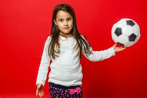 liten flicka med de boll över röd backgrounf foto