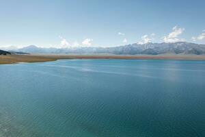 sjö och gräsmark med en solig dag. skott i sayram sjö i xinjiang, Kina. foto