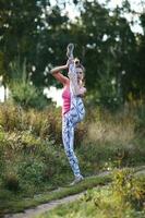 atletisk ung kvinna arbetssätt ut i de Land foto