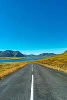 omslag sida med en asfalterad väg och isländsk färgrik och vild landskap med fjordar och hav på sommar tid, väst island foto