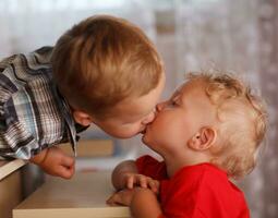 söt syskon. två liten bröder är kyssar. foto