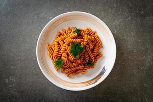 spiral- eller spiralipasta med tomatsås och korv - italiensk matstil foto
