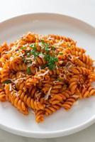 spiral- eller spiralipasta med tomatsås och korv - italiensk matstil foto