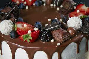kaka dekorerad med jordgubb och choklad på mörk bakgrund foto