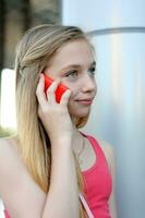 ung flicka talande på de telefon utomhus- foto