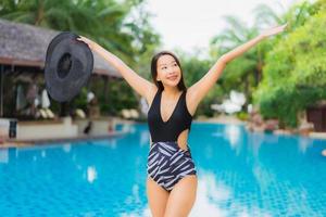porträtt vackra unga asiatiska kvinnor lyckligt leende koppla av runt poolen foto