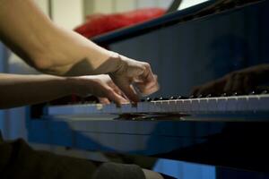 närbild på de händer av en kvinna spelar de piano med musik nycklar foto