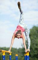 vig ung gymnast balansering på korsa barer foto