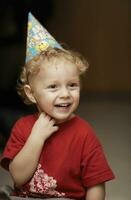 söt Lycklig ung pojke i en fest hatt foto