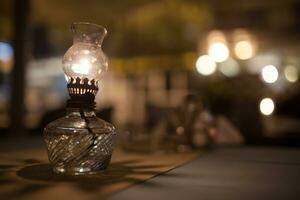 antik olja lampa med dämpa ljus på tabell i Kafé foto