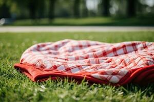 röd och vit pläd picknick filt på topp av en grön fält i solig dag på gräs av gräsmatta i sommar parkera. suddig bakgrund. generativ ai foto