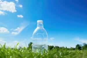 en plast flaska på gräsmatta med blå himmel i de bakgrund . foto