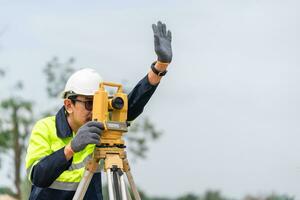 besiktningsman civil ingenjör hand signal med Utrustning på de konstruktion webbplats. foto