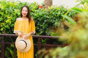 porträtt vacker ung asiatisk kvinna lyckligt leende lesire i trädgården parkerar