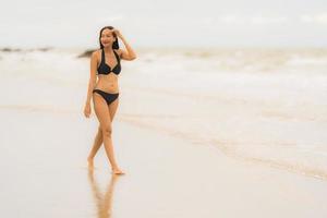 porträtt vacker ung asiatisk kvinna slitage bikini på stranden havet havet foto