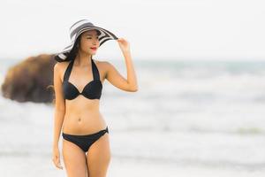 porträtt vacker ung asiatisk kvinna slitage bikini på stranden havet havet foto
