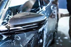 närbild bil sidospegel med bil tvätt skum foto