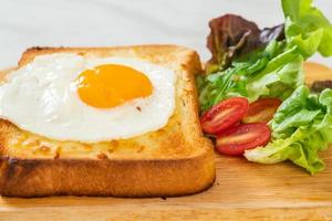 hemlagat bröd rostat med ost och stekt ägg på toppen med grönsaksallad till frukost foto