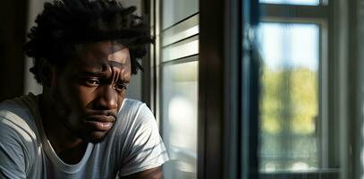 en ledsen afrikansk amerikan man i de fönster på Hem. ensamhet begrepp. ai genererad foto