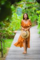 porträtt vacker ung asiatisk kvinna promenad på stig promenad i trädgården foto