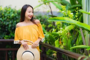 porträtt vacker ung asiatisk kvinna lyckligt leende lesire i trädgården parkerar
