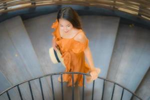 porträtt vacker ung asiatisk kvinna gå på cirkel trappa foto