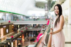 vacker asiatisk kvinnaleende och glad i köpcentrum foto