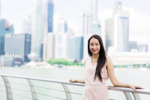 vacker asiatisk kvinna leende och glad att resa i singapore city foto