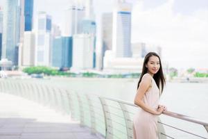vacker asiatisk kvinna leende och glad att resa i singapore city foto