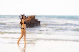 porträtt vacker ung asiatisk kvinna slitage bikini på stranden havet havet foto