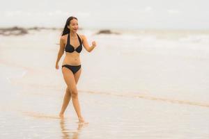 porträtt vacker ung asiatisk kvinna slitage bikini på stranden havet havet foto