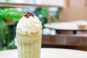 matcha grönt te latte blandad med vispad grädde och röd böna i kafé och restaurang foto