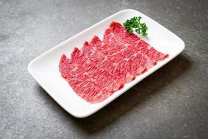 färskt nötkött rå skivad med marmorerad konsistens serveras till sukiyaki och shabu eller yakiniku foto