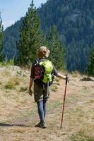 ung kvinna resenär med ryggsäck i bergen foto