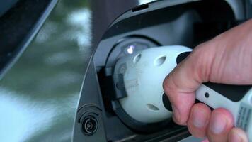 öppen - stänga lock laddar, stänga upp hand man införing plugg in i laddning elektrisk bil. foto