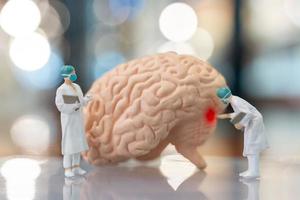 miniatyrläkare och sjuksköterska som observerar och diskuterar om mänsklig hjärna