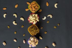 hälsosam blandning torra frukter och nötter på mörk bakgrund. mandlar, pistasch, cashewnötter, russin foto