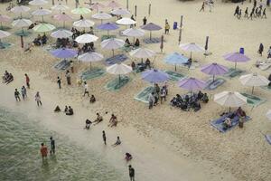antenn Drönare se av Semester i ndrini strand, yogyakarta, indonesien med hav, strand, paraplyer, och människor. foto