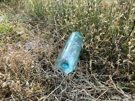 en flaska av vatten i de skog. miljö- problem. foto