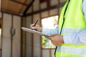 inspektör eller ingenjör är inspekterande konstruktion och kvalitet försäkran ny hus använder sig av en checklista. ingenjörer eller arkitekter eller kontaktor arbete till bygga de hus innan lämnandet den över till de husägare foto