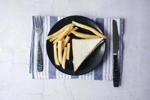 skiva kycklingmacka och chips på plattan, ovanifrån foto
